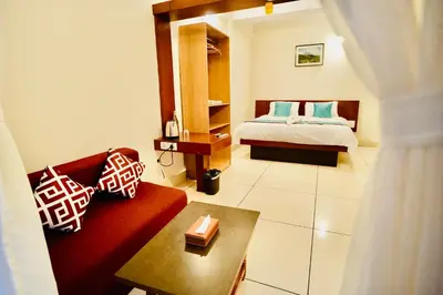 a bedroom with a bed and a red couch at GVK Holiday Inn in Mysore