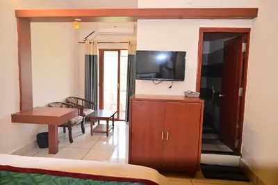 a room with a living room with a tv and a couch at GVK Holiday Inn in Mysore