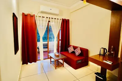 a living room with a red chair and a window at GVK Holiday Inn in Mysore