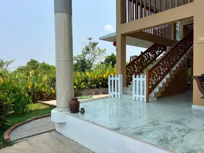 a porch of a house with stairs and plants at Room Marakkech Mazha at Samava Farms Calicut in Kozhikode