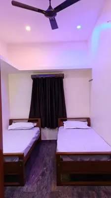 two beds in a room with a ceiling fan at Eagles Nest in Dimbam