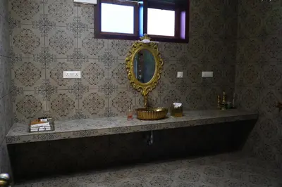 a bathroom with a sink and a mirror on the wall at Room Suvira at Samava Farms Calicut in Kozhikode