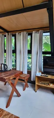a room with a table and some windows at Cherry Blossoms Chalet in Kozhikode
