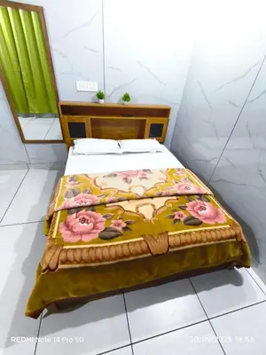 a bed with a blanket with flowers on it at Diyara's Inn in Madikeri