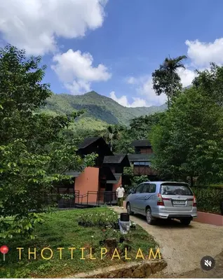a car parked in a driveway in front of a house at Vanillafarms in Wayanad
