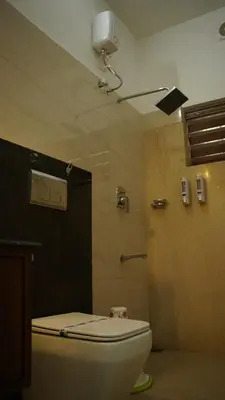 a bathroom with a toilet and a shower at Hotel Vintage Palace in Tattamangalam