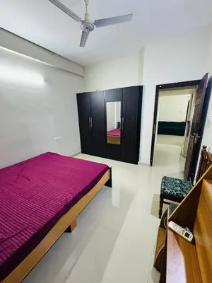 a bedroom with a bed and a chair in it at Harmony Nests in Thattakād