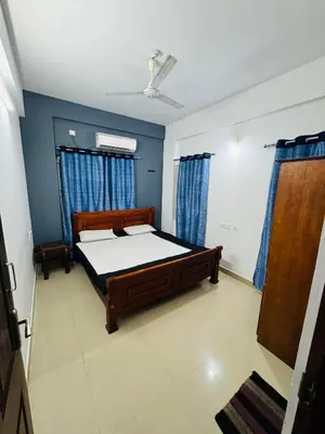 a bedroom with a bed and blue walls at Harmony Nests in Thattakād
