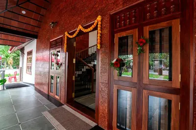 an entrance to a house with a wooden door at Dr Indulekhas Ayurvedic Wellness & Rejuvenation in Tellicherry