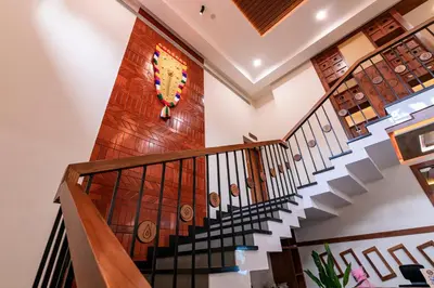 a staircase in a house with a wooden wall at Dr Indulekhas Ayurvedic Wellness & Rejuvenation in Tellicherry