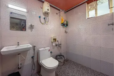 a bathroom with a toilet and a sink at Mayflower Family Lounge -Cochin Airport in Nedumbassery