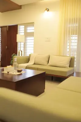 a living room with a couch and a coffee table at Kaayal Experience - Entire Home in Kozhikode in Kozhikode