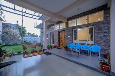 a house with a patio with blue chairs and a table at Spring Fields in Coimbatore