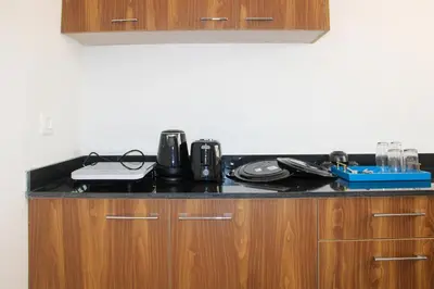 a kitchen counter top with a coffee maker on it at Jayasviinn Coorg in Virajpet