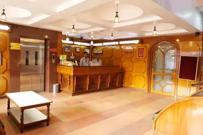 two people standing at a bar in a restaurant at Sakthi Hotel in Pollāchi