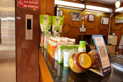 a counter in a store with many bottles of sauce at Sakthi Hotel in Pollāchi