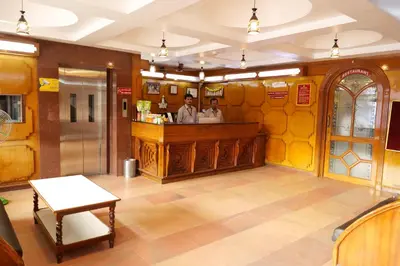 two people standing at a bar in a restaurant at Sakthi Hotel in Pollāchi