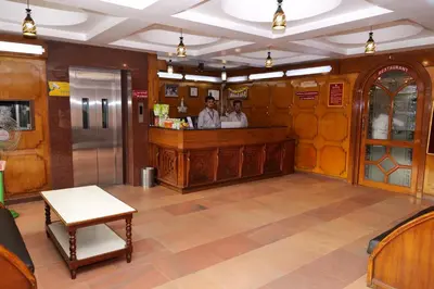 two people standing at a bar in a restaurant at Sakthi Hotel in Pollāchi