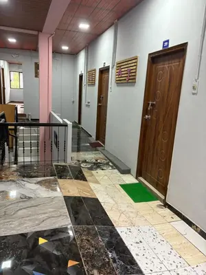 a corridor of a building with a damaged floor and doors at AJ GrandInn in Podanūr