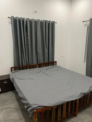 a bed with grey curtains in a room at Mynakam - A peaceful escape in Vythiri