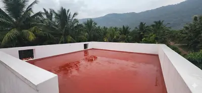 a pool of red water on the side of a building at LBS Farmstay in Alāndurai
