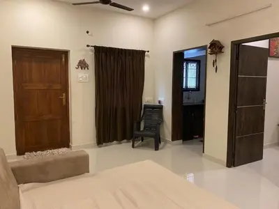 a living room with a couch and a chair at LBS Farmstay in Alāndurai