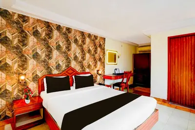 a bedroom with a large bed in a room at Collection O Puthali Park Near Mysuru Railway Station in Mysore