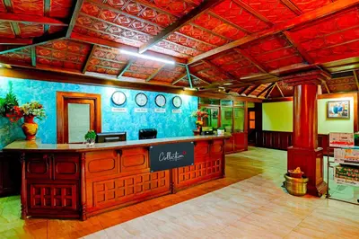 a restaurant with a bar in the middle of a room at Collection O Puthali Park Near Mysuru Railway Station in Mysore