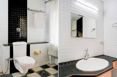 a white bathroom with a toilet and a sink at Collection O Puthali Park Near Mysuru Railway Station in Mysore