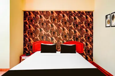a bedroom with a large bed with a red headboard at Collection O Puthali Park Near Mysuru Railway Station in Mysore