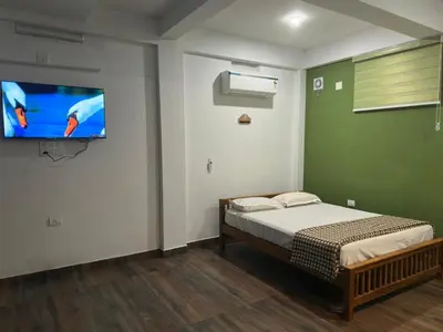 a bedroom with a bed and a flat screen tv at DB GUEST HOUSE ARIMPUR - Unmarried couples and Stag groups not allowed in Trichūr