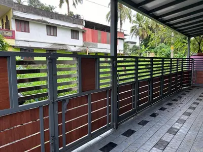 a wooden fence next to a building with a sidewalk at DB GUEST HOUSE ARIMPUR - Unmarried couples and Stag groups not allowed in Trichūr