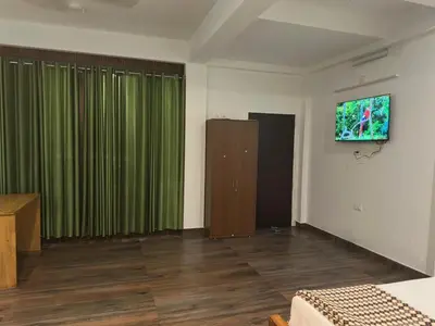 a room with a bed and a green curtain at DB GUEST HOUSE ARIMPUR - Unmarried couples and Stag groups not allowed in Trichūr