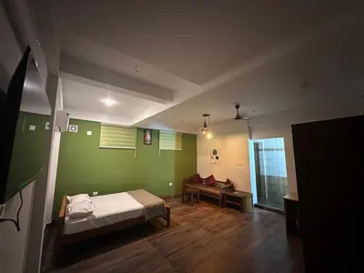 a bedroom with a bed and a green wall at DB GUEST HOUSE ARIMPUR - Unmarried couples and Stag groups not allowed in Trichūr