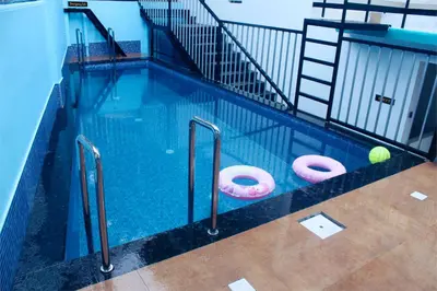 a swimming pool with two pink donuts in it at VGK Residency in Wayanad