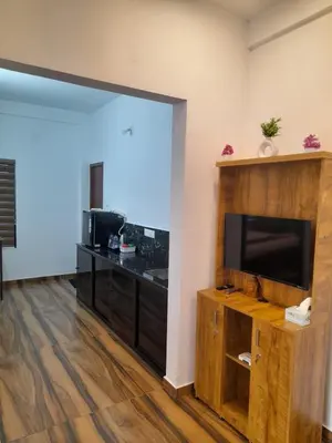 a living room with a flat screen tv and a entertainment center at VGK Residency in Wayanad