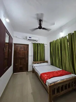 a bedroom with a bed with green curtains and a ceiling at Raya Casa Couple Suite 101 in Guruvāyūr