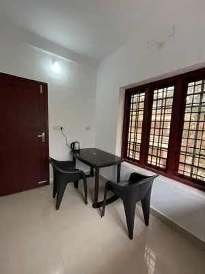 a dining room with a table and two chairs at Raya Casa Couple Suite 101 in Guruvāyūr