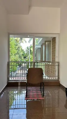 a chair sitting on a balcony in a room at Snehanilayam in Trichūr