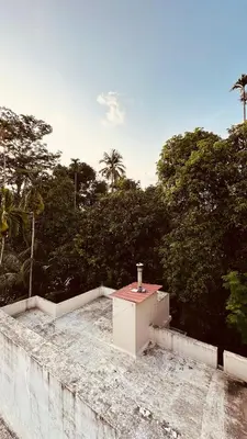 a roof of a building with trees in the background at Snehanilayam in Trichūr