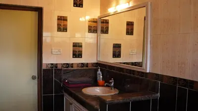 a bathroom with a sink and a mirror at Aarroh villa in Coonoor