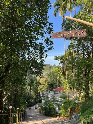 a sign hanging from a pole in a park at Oryx Villai in Vythiri