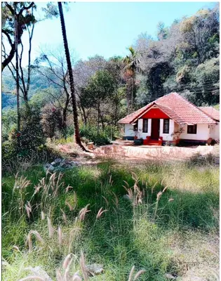 a small red and white house in the middle of a field at Vintage Breeze Home Stay in Madikeri