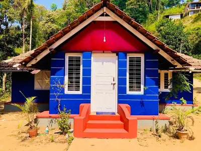 a blue and red house with a red roof at Vintage Breeze Home Stay in Madikeri
