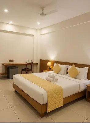 a bedroom with a large bed and a desk at Devalokam Edappal in Edappāl