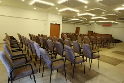 a room with a row of chairs in a hall at Devalokam Edappal in Edappāl
