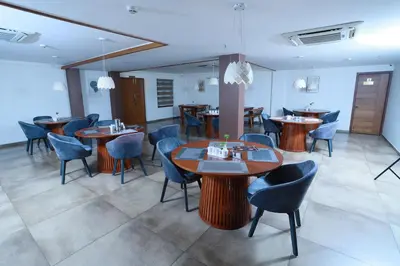 a restaurant with tables and chairs in a room at Devalokam Edappal in Edappāl