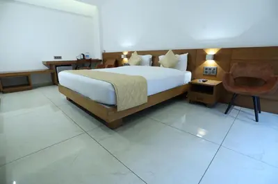 a bedroom with a large bed and a chair at Devalokam Edappal in Edappāl