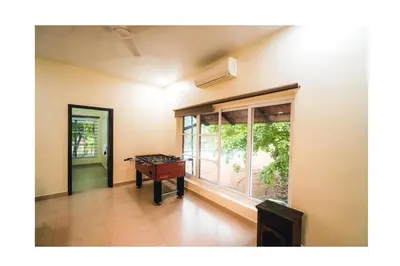 a room with a table and a large window at Vetha farm in Aravakkurichchi