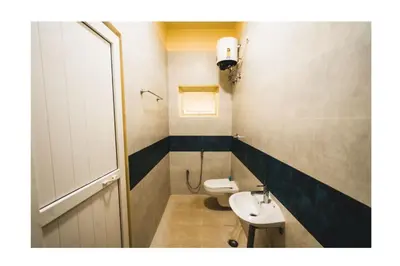 a bathroom with a white toilet and a sink at Vetha farm in Aravakkurichchi